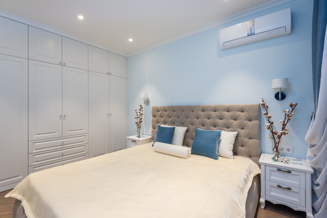 A beautifully designed bedroom with elegant decor, blue accents, and cozy furnishings.